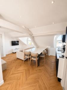 a kitchen and dining room with a table and chairs at The Originals Residence, Les Sources Callou, Vichy in Vichy