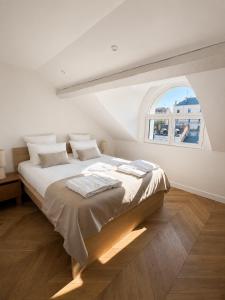 a white bedroom with a large bed with a window at The Originals Residence, Les Sources Callou, Vichy in Vichy