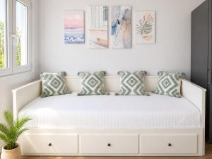 a bedroom with a white bed with pillows on it at Elli's House - Apartment in Lixouri