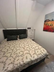a bedroom with a bed and a painting on the wall at The Alpine Poolhouse in Trnovo +17 photos