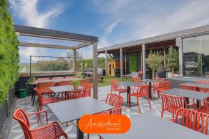 an outdoor patio with tables and chairs and windows at Amsterdam Group Villa 20 plus guests with Spa and Karaoke in Zwanenburg