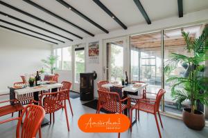 a restaurant with red chairs and tables and windows at Amsterdam Group Villa 20 plus guests with Spa and Karaoke in Zwanenburg