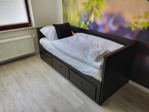 a black bed with white sheets and pillows on it at Ferienwohnung Büffel in Niedenstein