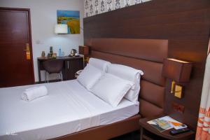 a hotel room with a bed with white pillows at New Heaven Hôtel in Yaoundé +115 photos