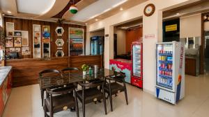a restaurant with a table and chairs and a refrigerator at Jhankor Hotel in Sīkar
