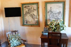 Pokój ze stołem i dwoma zdjęciami na ścianie w obiekcie Le Logge Ritrovate w mieście Acquasparta