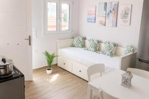 a white living room with a couch and a table at Elli's House - Apartment in Lixouri