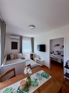 a living room with two beds and a dining room table at Holiday Village 8C in Senec