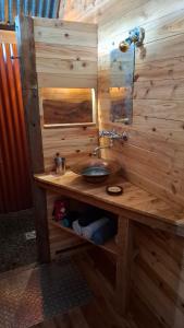 a wooden bathroom with a sink and a mirror at La Case Tonton de Petite Île in Petite Île