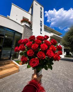 a person holding a bouquet of red roses at Athos Hotel in Riva del Garda