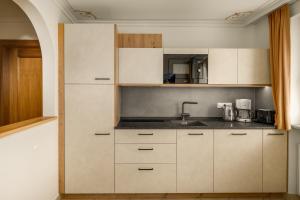 a kitchen with white cabinets and a sink at Residence Diana Apartment 103 in Terento