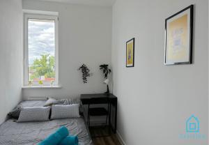 a bedroom with a bed and a desk and a window at Robot Room in Gdynia