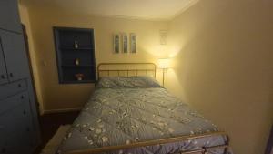 a small bedroom with a bed with a blue comforter at Anissa Shasta Hostel in Weed +7 photos