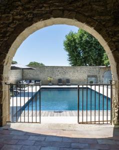 an archway leading to a swimming pool under a building at Le Mas de Sòmi in Aubais +12 photos