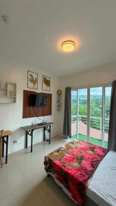 a bedroom with a bed and a desk and a window at Modena Town Square Minglanilla in Minglanilla