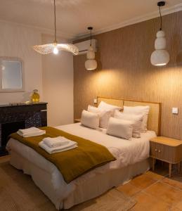 a bedroom with a large bed with towels on it at Le Mas de Sòmi in Aubais