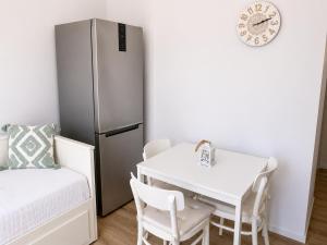 a small kitchen with a white table and a refrigerator at Elli's House - Apartment in Lixouri