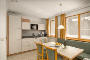 a kitchen with a table and some chairs and a table and a kitchen at Residence Diana Apartment 201 in Terento