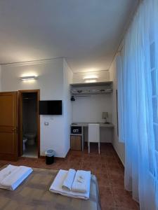 a room with two beds and a desk and a television at Hotel Alinari in Florence