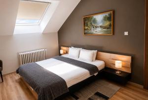 a bedroom with a bed and a painting on the wall at Veliki Garni Hotel in Novi Sad +86 photos