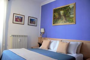 a bedroom with a bed with a painting on the wall at Città Eterna Guest House in Rome