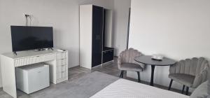 a bedroom with a bed and a tv and a table at Villa Eliada in Tuzla