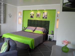 - une chambre avec un lit et un mur vert dans l'établissement A Mandria, à Porticcio