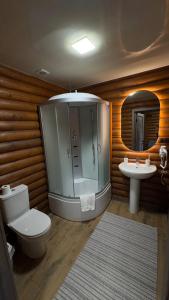 a bathroom with a shower and a toilet and a sink at Готель Кумир in Rivne