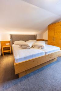 a bed with white sheets and pillows in a room at Haus Hubertus in Galtür