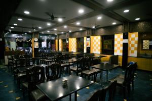 a dining room with tables and chairs in a restaurant at Hotel Raaj Bhaavan - US Consulate - Nungambakkam in Chennai