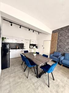 a kitchen and dining room with a table and blue chairs at Teplice Apartments 1 in Teplice