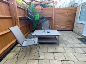 a patio with a table and chairs and a fence at Rooms in stylish house in Milton Keynes