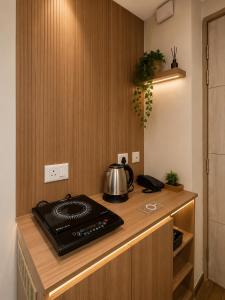 a kitchen counter with a tea kettle on a stove at The Sky cabin in Greater Noida