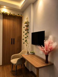 a living room with a wooden table and a television at The Sky cabin in Greater Noida +1 photo