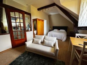 a bedroom with a bed and a chair and a table at Le Moulin de l`Epinay in Sainte-Beuve-en-Rivière