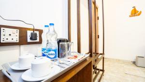 a table with two bottles of water and cups on it at Sansevieria Homestay in Sigiriya
