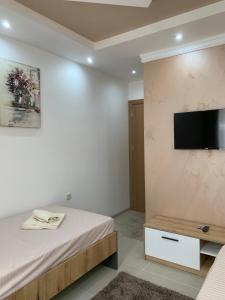 a bedroom with a bed and a tv on a wall at Eliksir 2 in Gornja Trepča