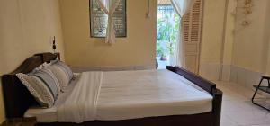 a bedroom with a bed in a room with a window at Home Can Tho in Can Tho