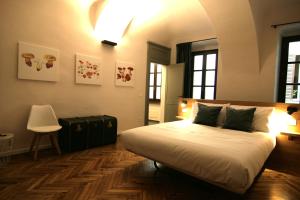 a bedroom with a large white bed and a chair at Residenza Basiglio in Ceva