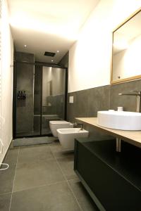 a bathroom with three sinks and a shower at Residenza Basiglio in Ceva