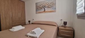 a bedroom with a bed with two towels on it at Sa Omu de S'Olia in Tertenìa