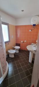 a bathroom with three sinks and two toilets at Sa Omu de S'Olia in Tertenìa +25 photos