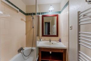 a bathroom with a sink and a tub and a mirror at Golf de Biscarrosse – Piscine in Biscarrosse +14 photos