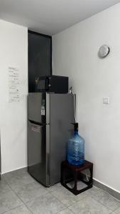 a black refrigerator and a blue vase on a table at Authentic Galore in Ongata Rongai 