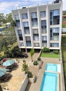 an apartment building with a pool in front of it at Authentic Galore in Ongata Rongai 