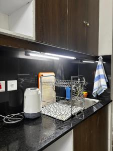 a kitchen counter with a drying rack and a toaster at Authentic Galore in Ongata Rongai 