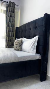 a bed with a black headboard with a pillow on it at Authentic Galore in Ongata Rongai 