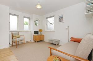 a living room with a couch and a desk and windows at City Centre Haven Apartments in Edinburgh