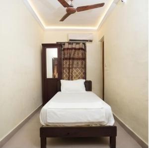 a bedroom with a bed with a ceiling fan at Hotel Malabar Plaza in Cochin