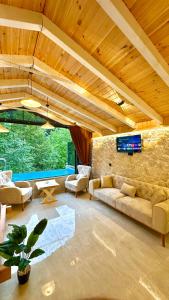 a large living room with couches and a stone wall at Waterfall suit bungalov in Çamlıhemşin
